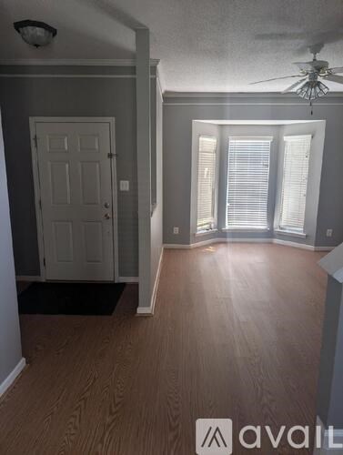 A room with a door and a fan on the ceiling.