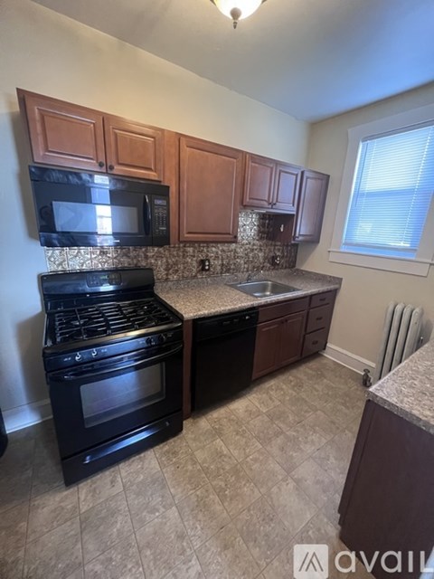 A kitchen with a black stove top oven and black microwave.