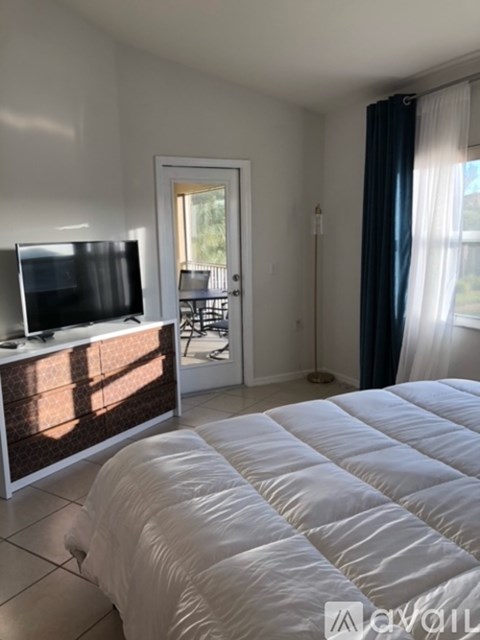 A bedroom with a large bed and a flat screen TV.