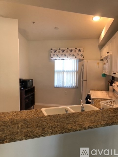 A kitchen with granite countertops and white cabinets.