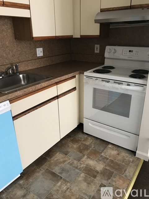 A kitchen with a white oven and a blue dishwasher.