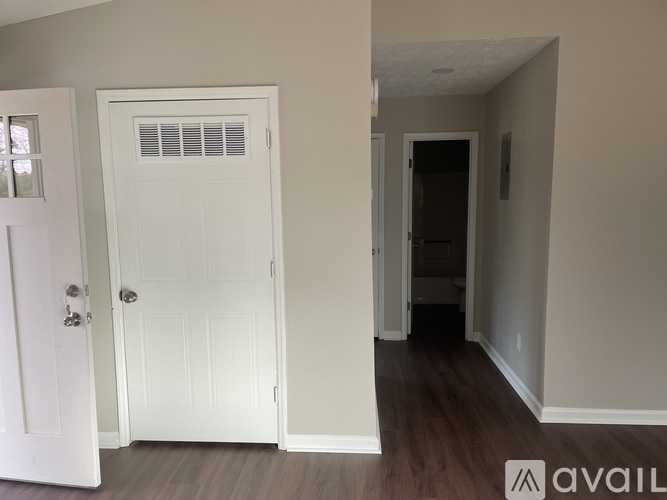 A white door with a window above it in a room with wooden floors.