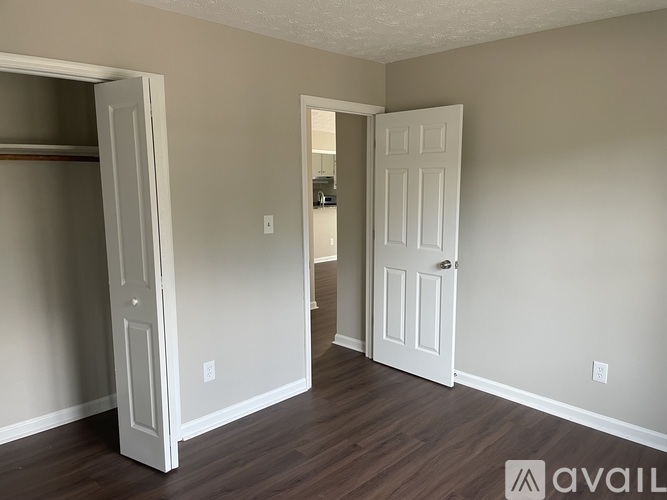 A room with two white doors and a wooden floor.
