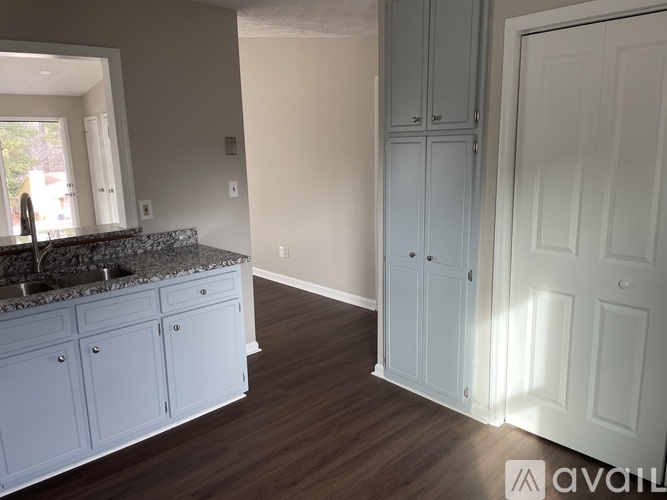 A kitchen with white cabinets and a granite countertop.