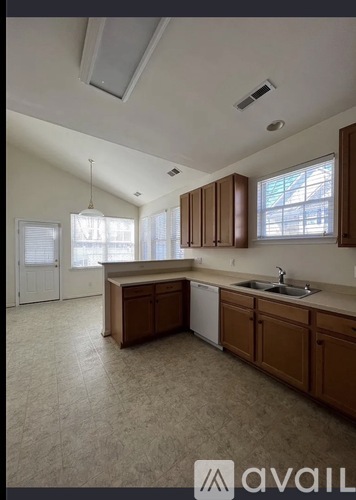 A kitchen with brown cabinets and a white dishwasher.