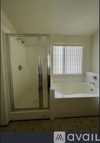 A bathroom with a glass door shower and a bathtub.