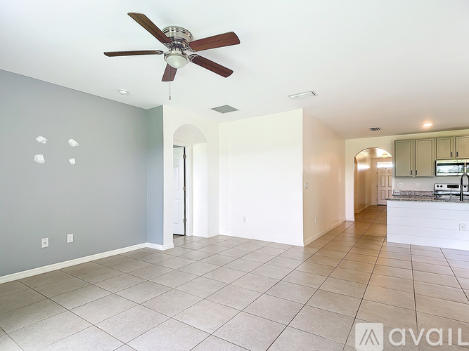 A spacious room with a ceiling fan and tiled flooring.