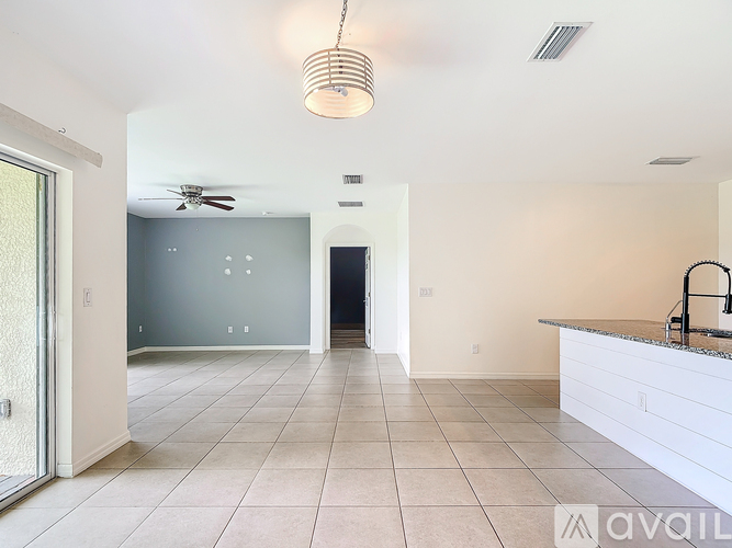 A kitchen with a white counter and a ceiling fan.