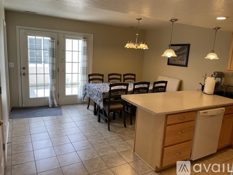 A kitchen with a dining table set up with chairs.