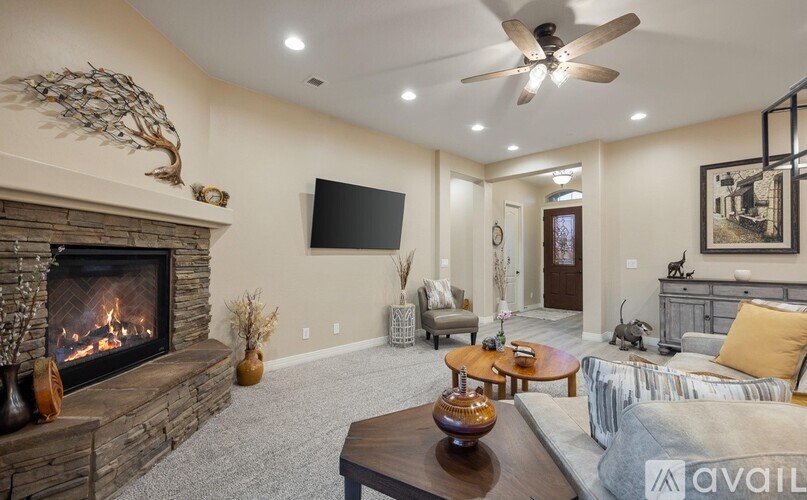 A living room with a fireplace and a television mounted on the wall.