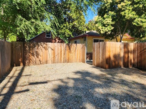 A backyard with a wooden fence and trees.