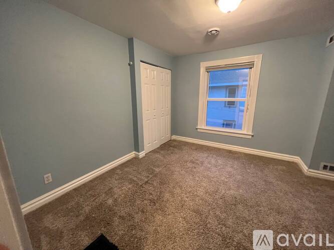 A room with a carpeted floor and a window.