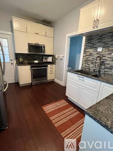 A kitchen with white cabinets and a black stove top oven.