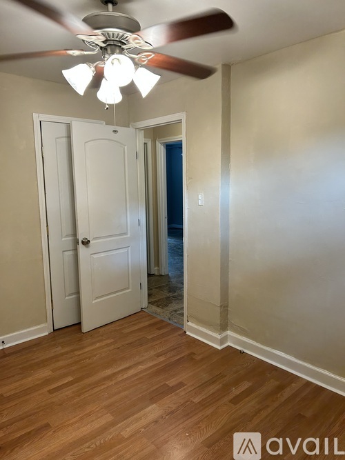 A room with a ceiling fan and two doors.