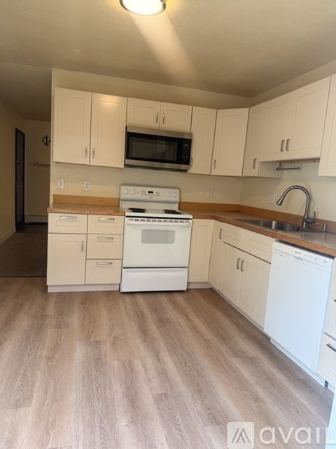 A kitchen with white appliances and cabinets.