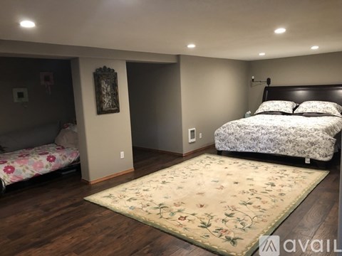 A bedroom with a large bed and a floral rug.