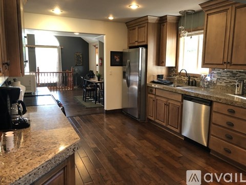 A kitchen with wooden cabinets and a marble countertop.