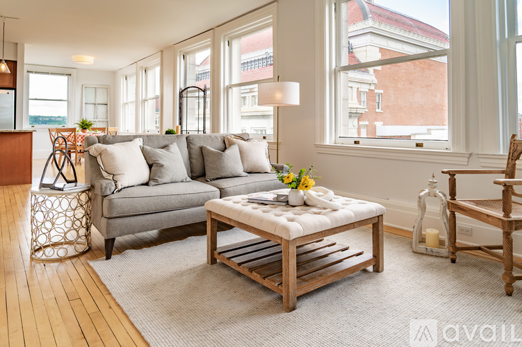 A living room with a grey couch and a wooden coffee table.