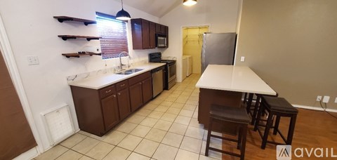 A kitchen with brown cabinets and a white counter top.
