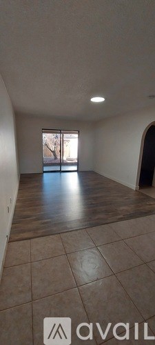 A room with a large window and tiled flooring.