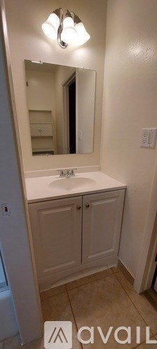 A bathroom with a sink, mirror, and medicine cabinet.