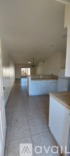 A kitchen with white cabinets and a tiled floor.