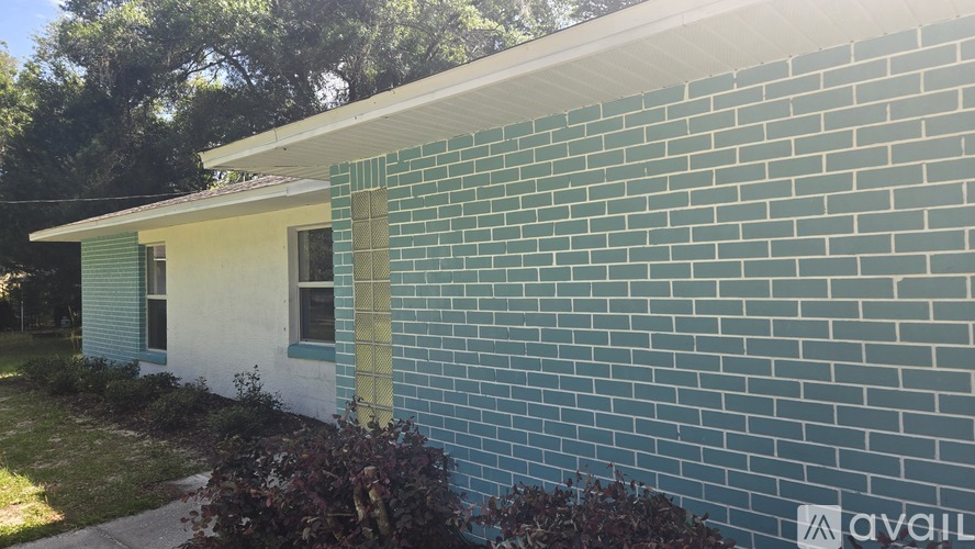 A house with a blue brick wall and a white roof.