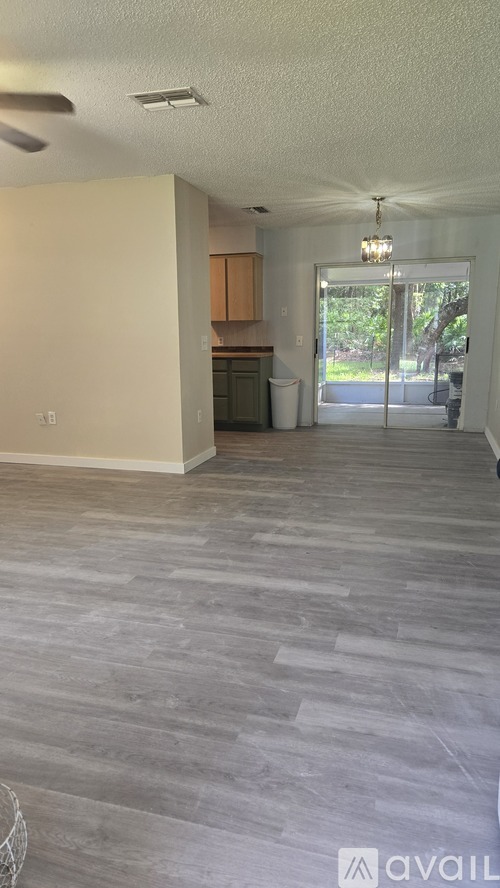 A spacious room with wooden flooring and a ceiling fan.