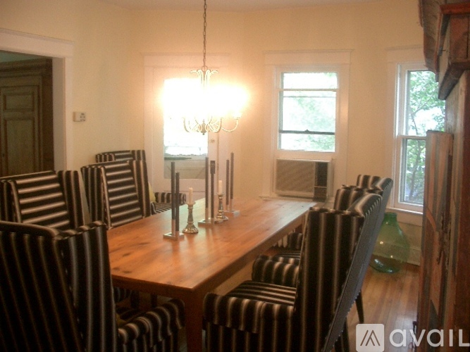 A dining room with a wooden table and striped chairs.