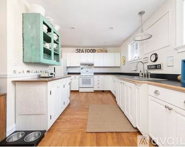 A kitchen with white cabinets and a green cabinet.