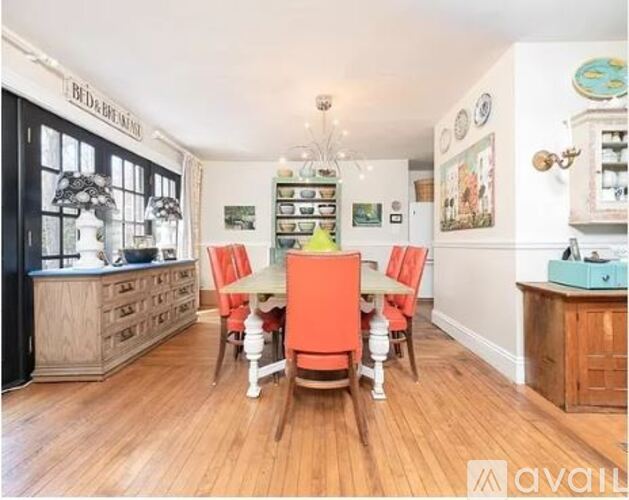 A dining room with a wooden table and chairs.