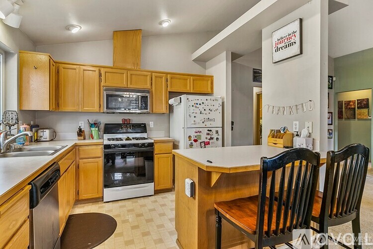 A kitchen with wooden cabinets and a white fridge.