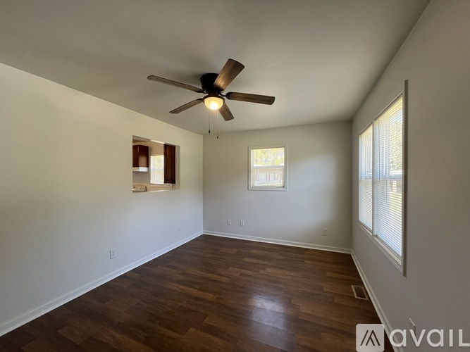 A room with a ceiling fan and wooden flooring.