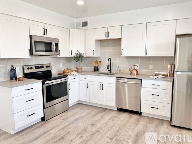 A kitchen with white cabinets and stainless steel appliances.