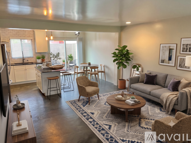 A living room with a grey couch, a wooden coffee table, and a rug with a blue and white pattern.