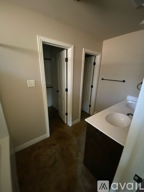 A bathroom with a sink, mirror, and two doors.