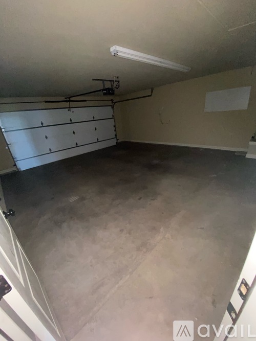 A large empty room with a grey floor and a white ceiling.
