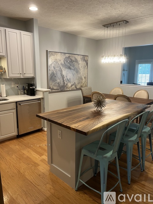 A kitchen with a wooden table and chairs.