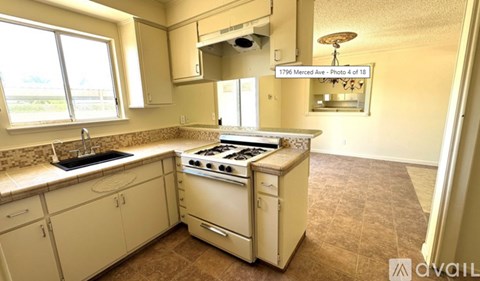 A kitchen with a white stove and sink.