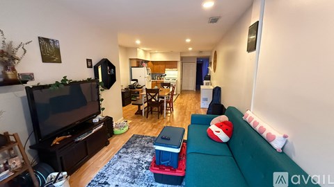 A living room with a green couch and a television.