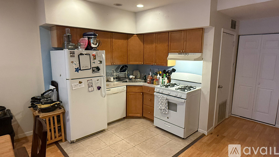 A kitchen with white appliances and wooden cabinets.