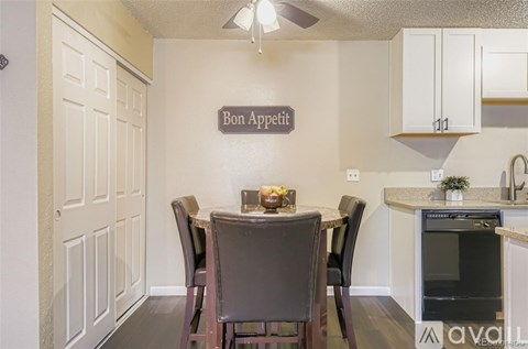 A kitchen with a dining table and chairs and a sign that says Bon Appetit.