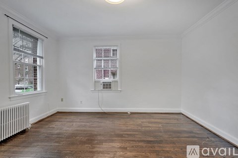 A room with wooden floors and a window with blinds.