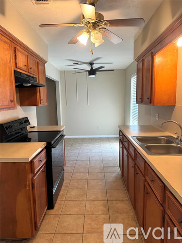 A kitchen with wooden cabinets and a black stove top oven.