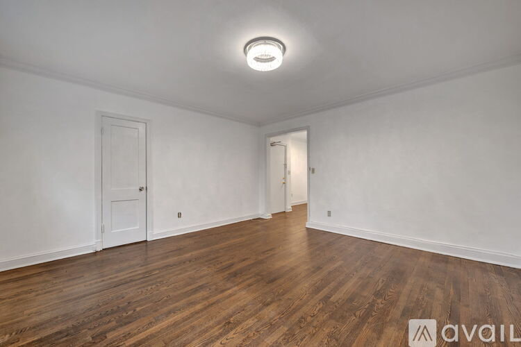 A room with wooden floors and two doors.