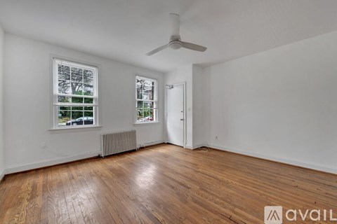 A room with wooden floors and a ceiling fan.