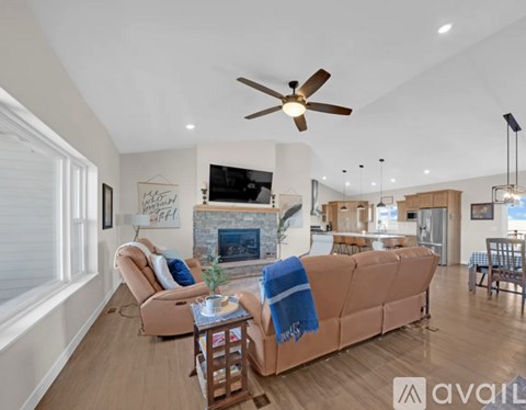 A living room with a brown couch and a ceiling fan.