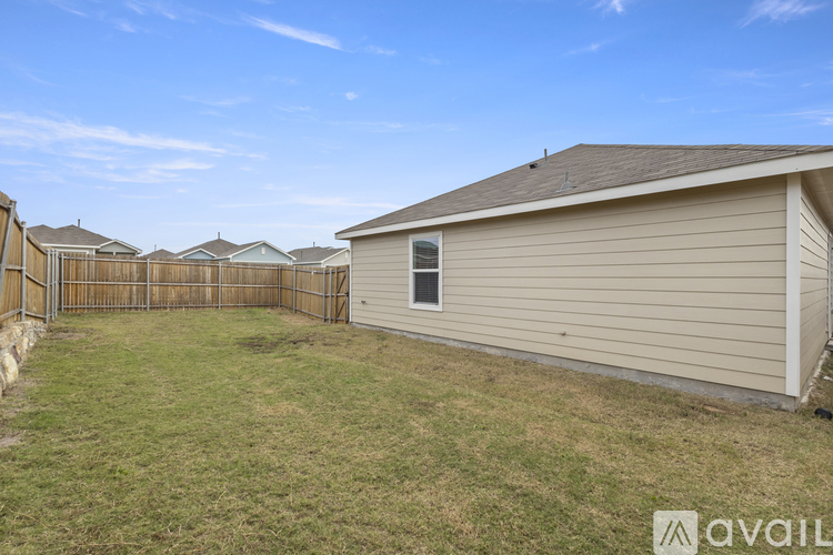 A house with a fence and a grassy yard is available for rent.