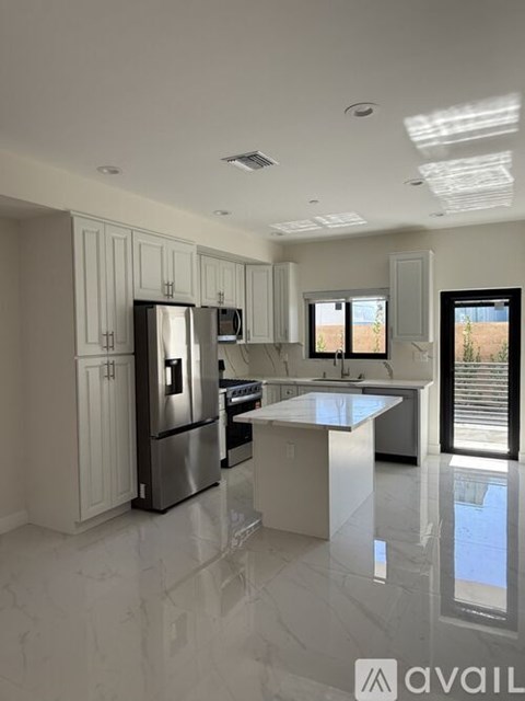 A modern kitchen with stainless steel appliances and white cabinets.