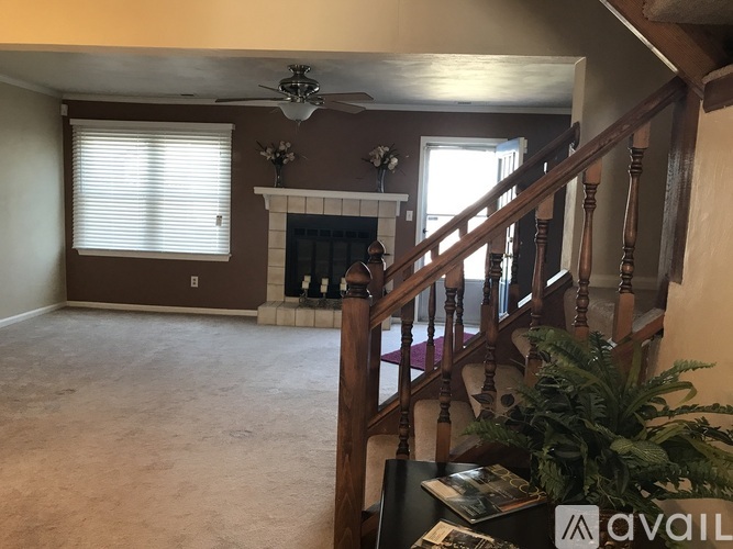 A living room with a fireplace and a staircase.